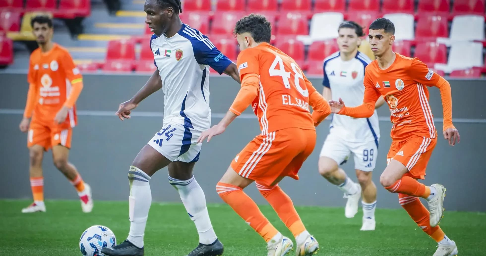 Al Wahda U23 player dribbling past Khorfakkan U23 players