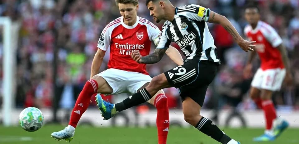 Newcastle player kicking the ball against Arsenal