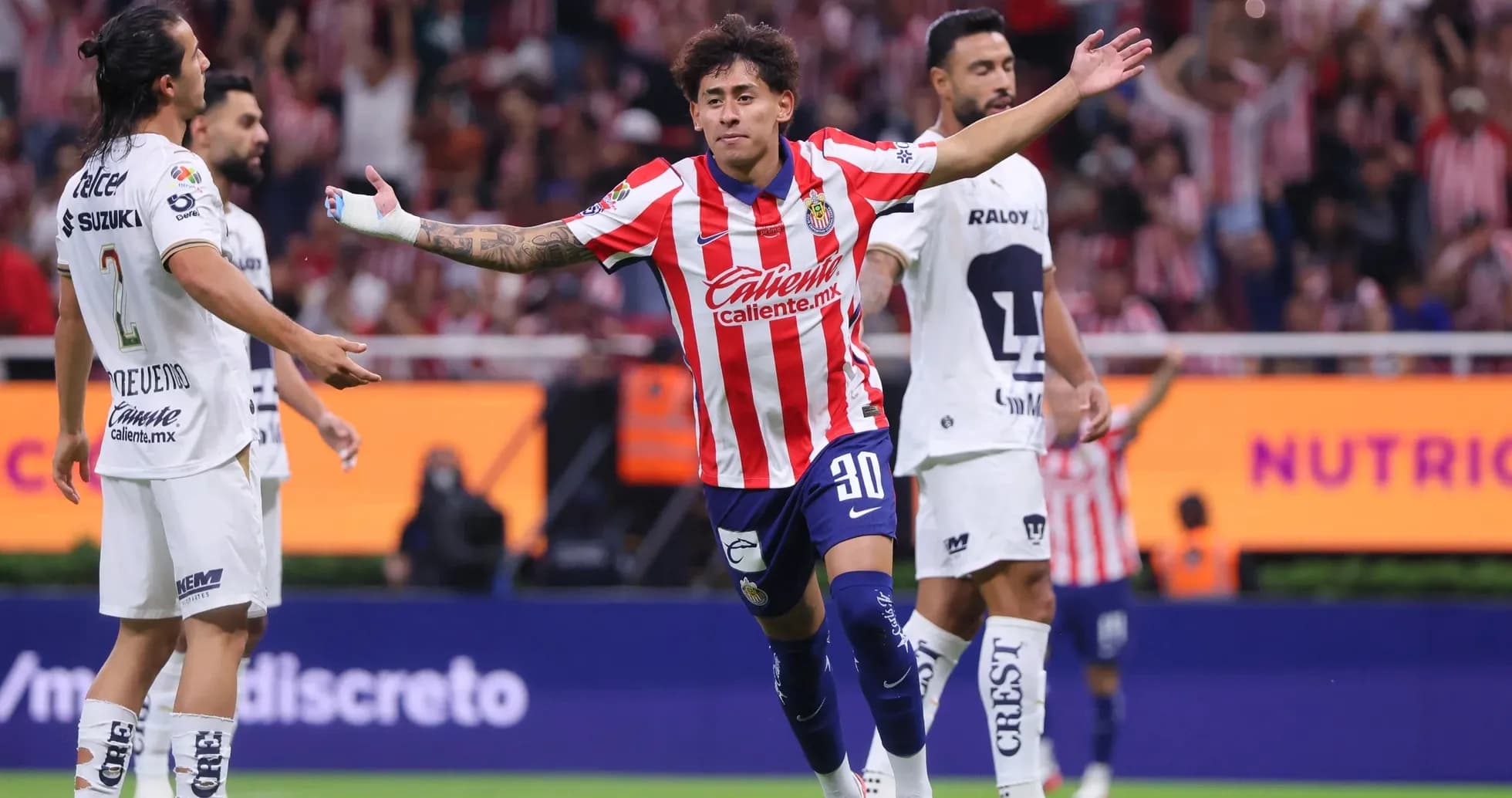 Chivas player celebrating a goal against Pumas