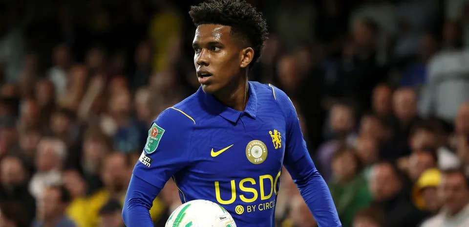 Player in blue jersey holding a soccer ball