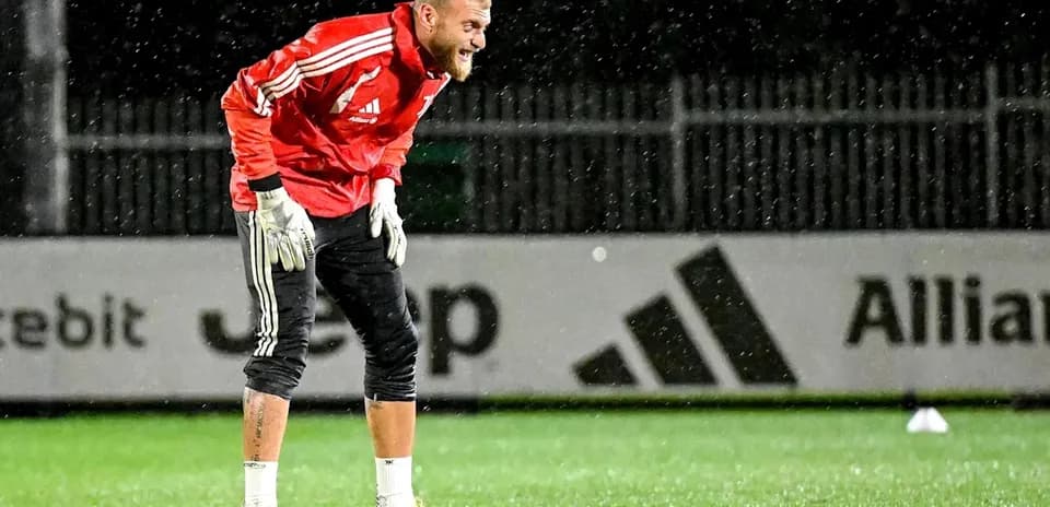 Goalkeeper training in rain at football pitch