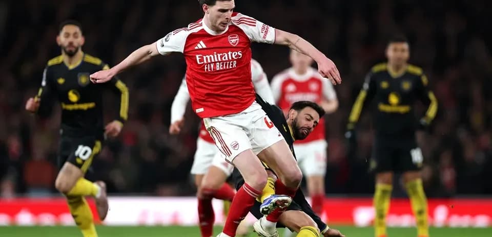 Arsenal player evading tackle during match action