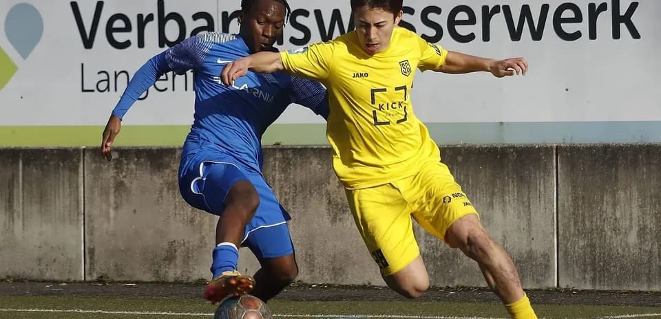 Two players competing for the ball during match