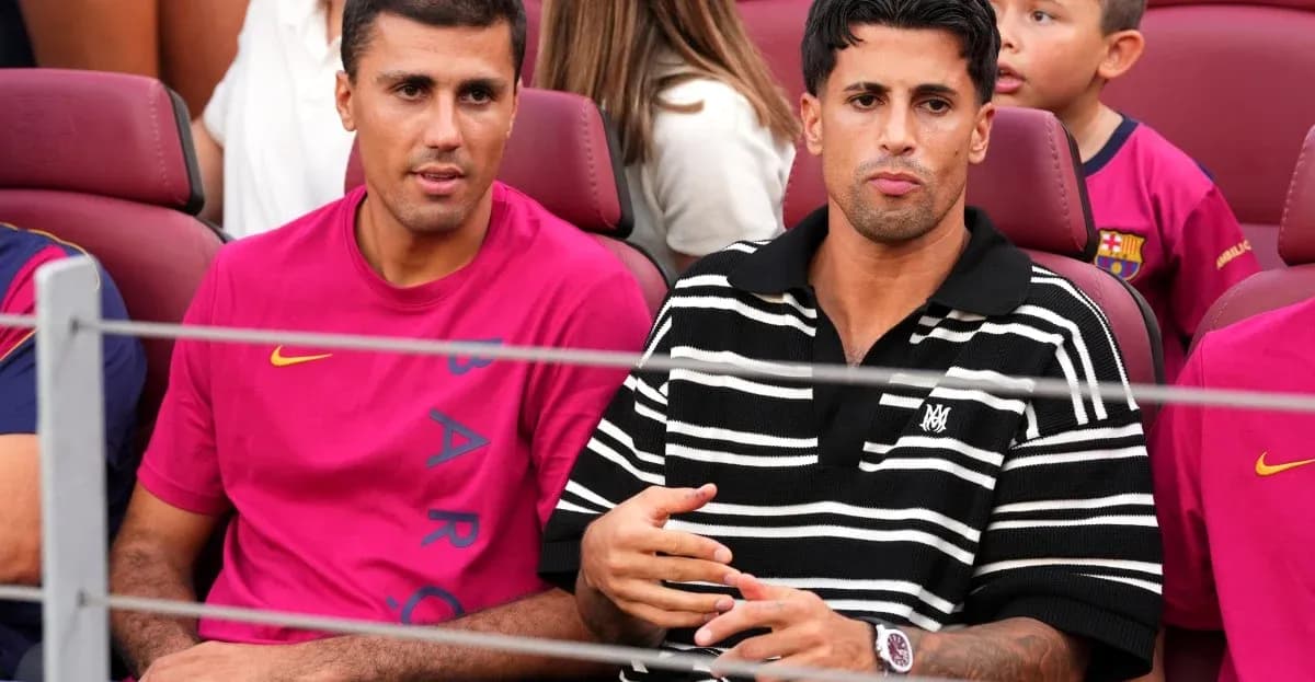 Two men seated in stadium wearing Barcelona jerseys