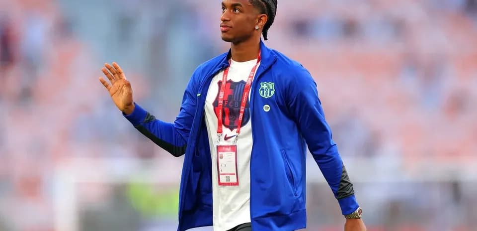 Player waving while wearing team jacket before match