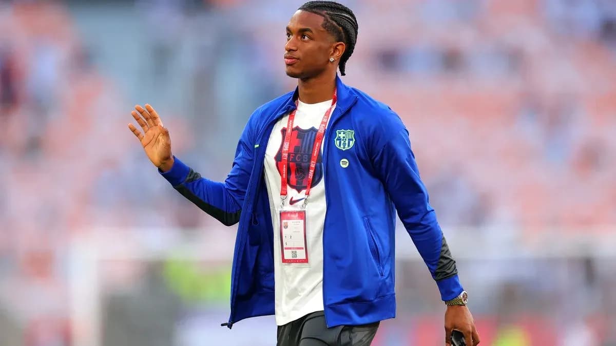 Player waving while wearing team jacket before match
