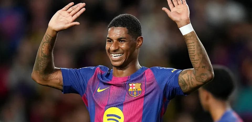 Player celebrating with raised hands in Barcelona jersey