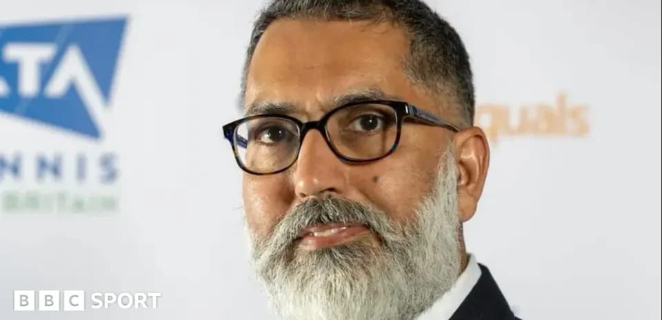 Man with glasses posing at a press event