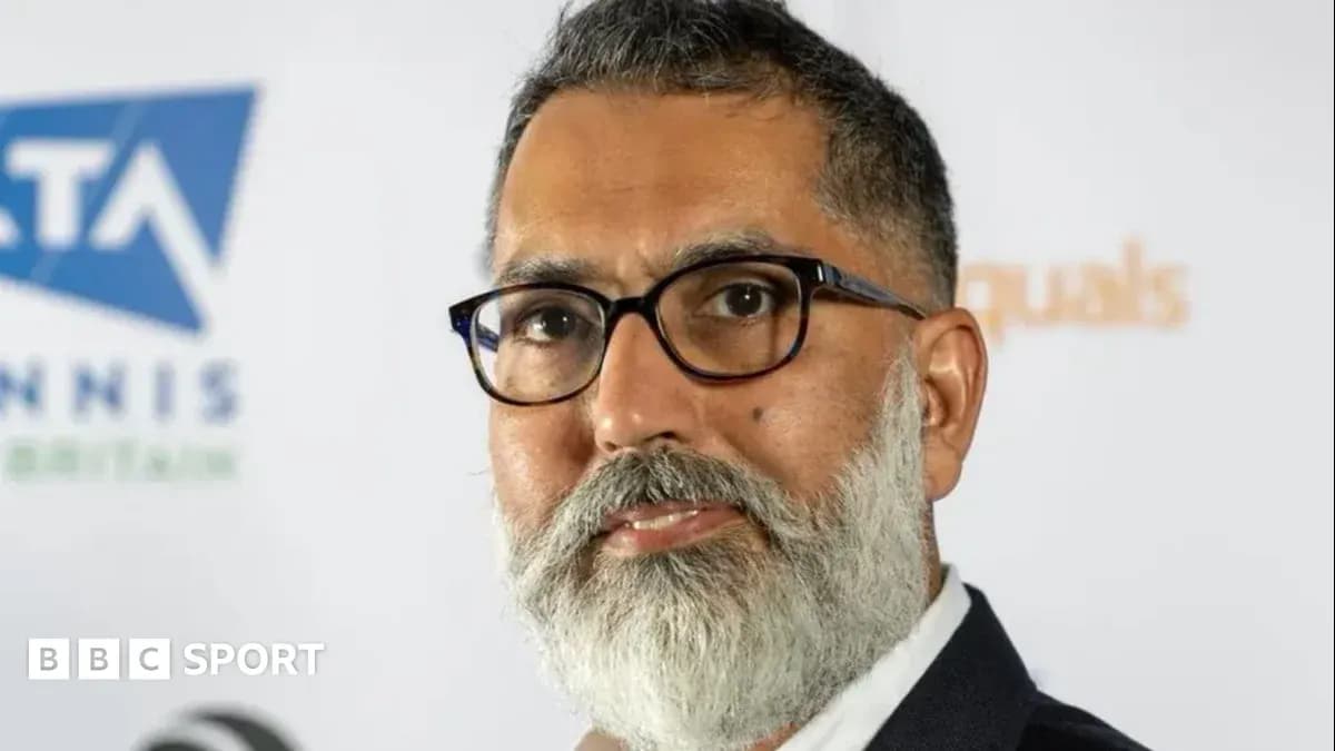 Man with glasses posing at a press event