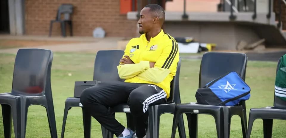 Coach seated on bench during training session