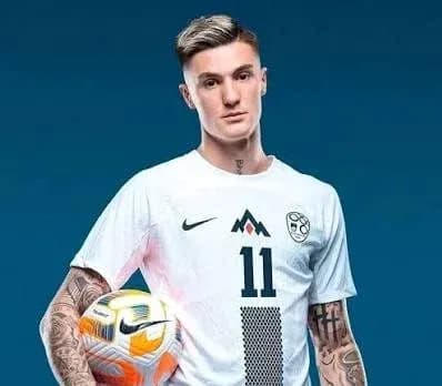 Player holding a soccer ball in team jersey