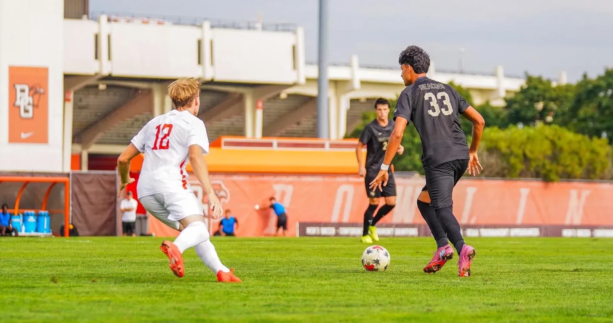 Player in white jersey chasing ball held by opponent