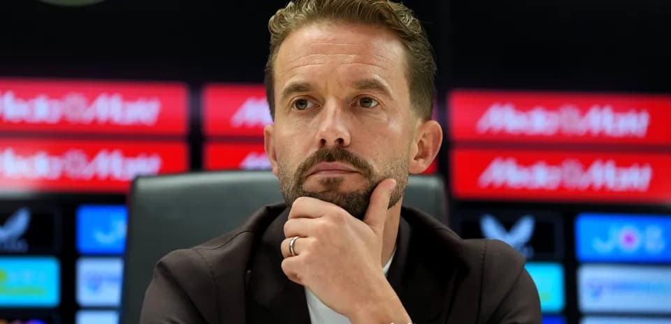 Manager at press conference with thoughtful expression