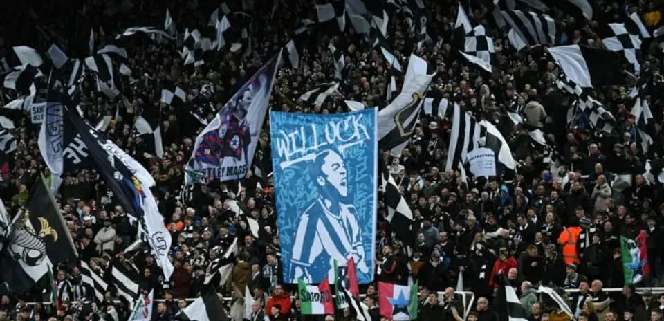 Newcastle United fans waving flags in stadium