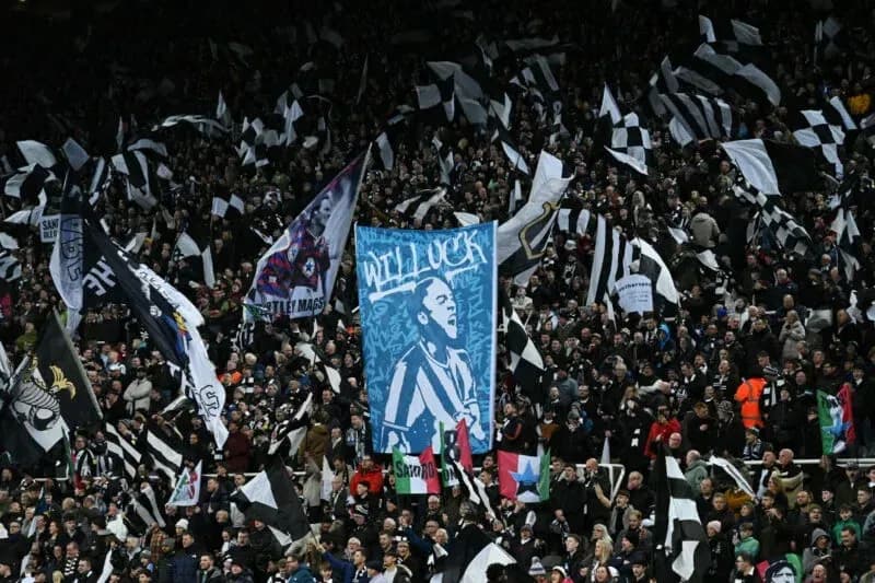 Newcastle United fans waving flags in stadium
