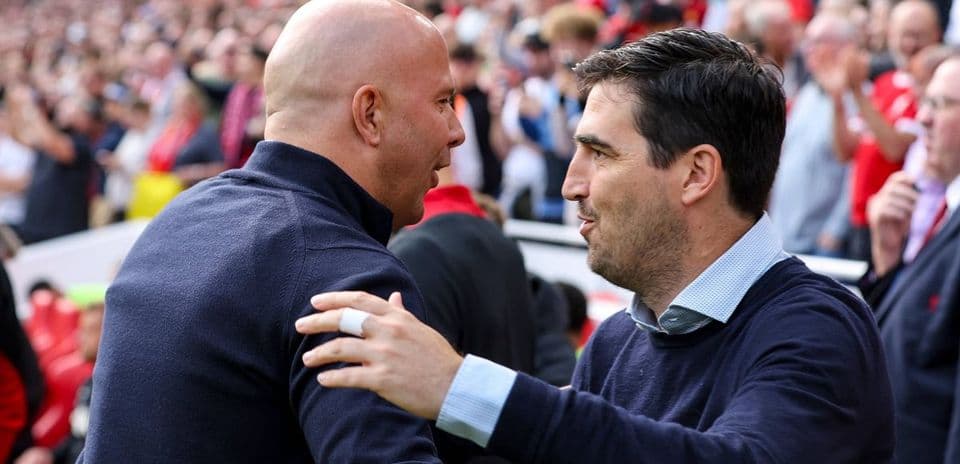 Two coaches greeting each other on the sidelines