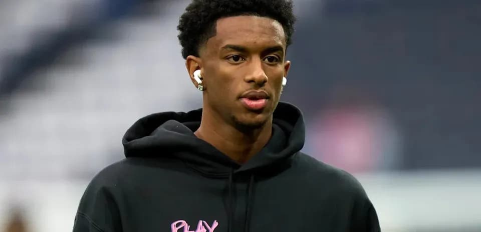 Player wearing a hoodie and earbuds before match