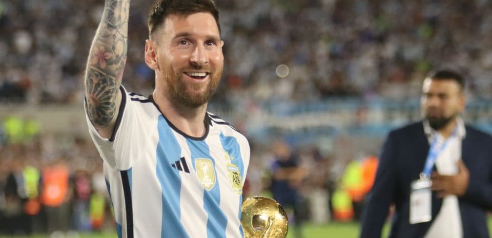 Player celebrating with World Cup trophy on field
