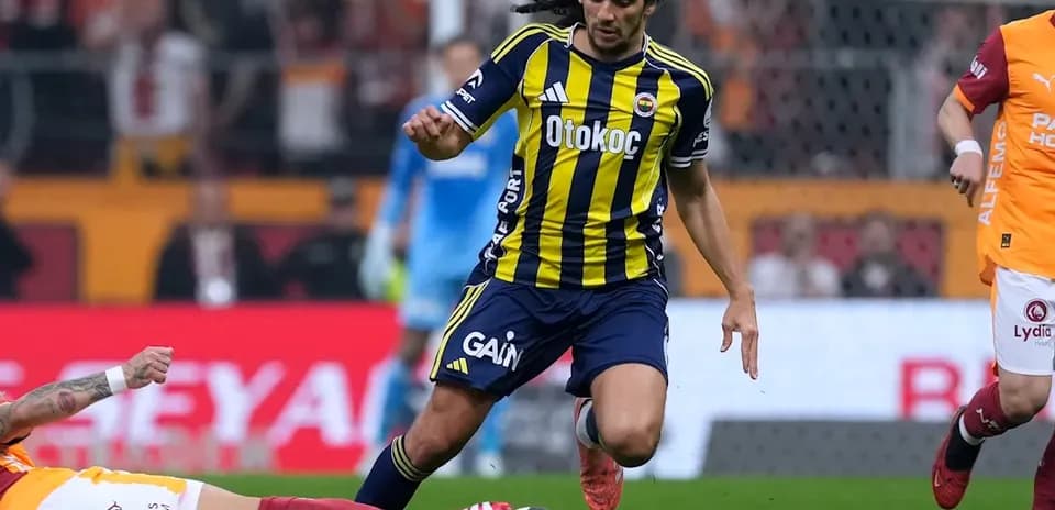 Fenerbahçe player dribbling past fallen opponent