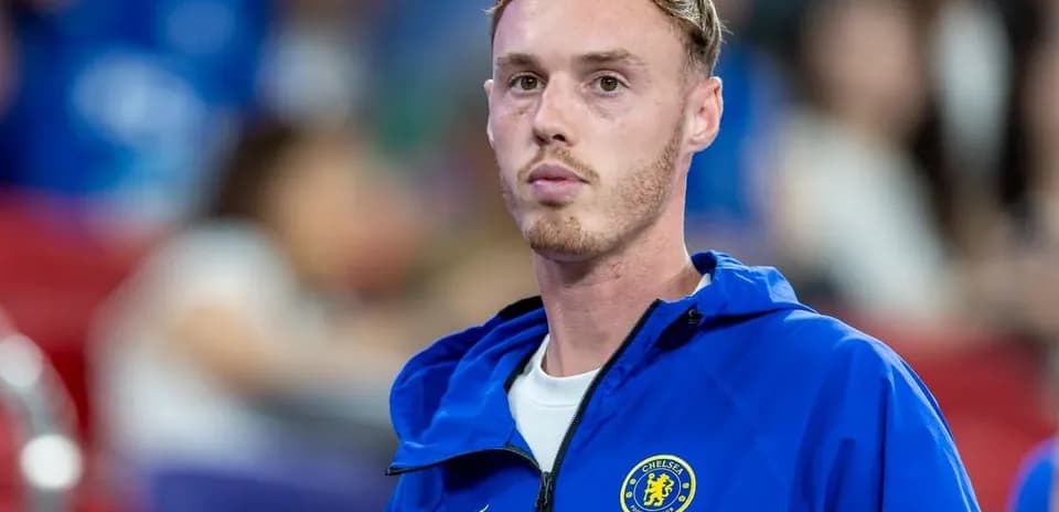 Chelsea player in blue jacket during match warm-up