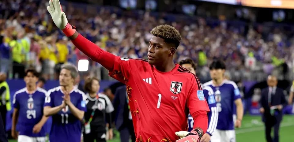 Goalkeeper waving after match with teammates behind