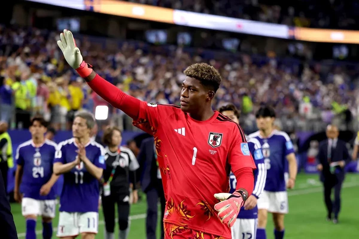 Goalkeeper waving after match with teammates behind