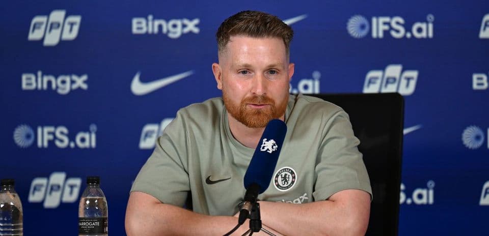 Manager speaking at press conference with sponsors backdrop