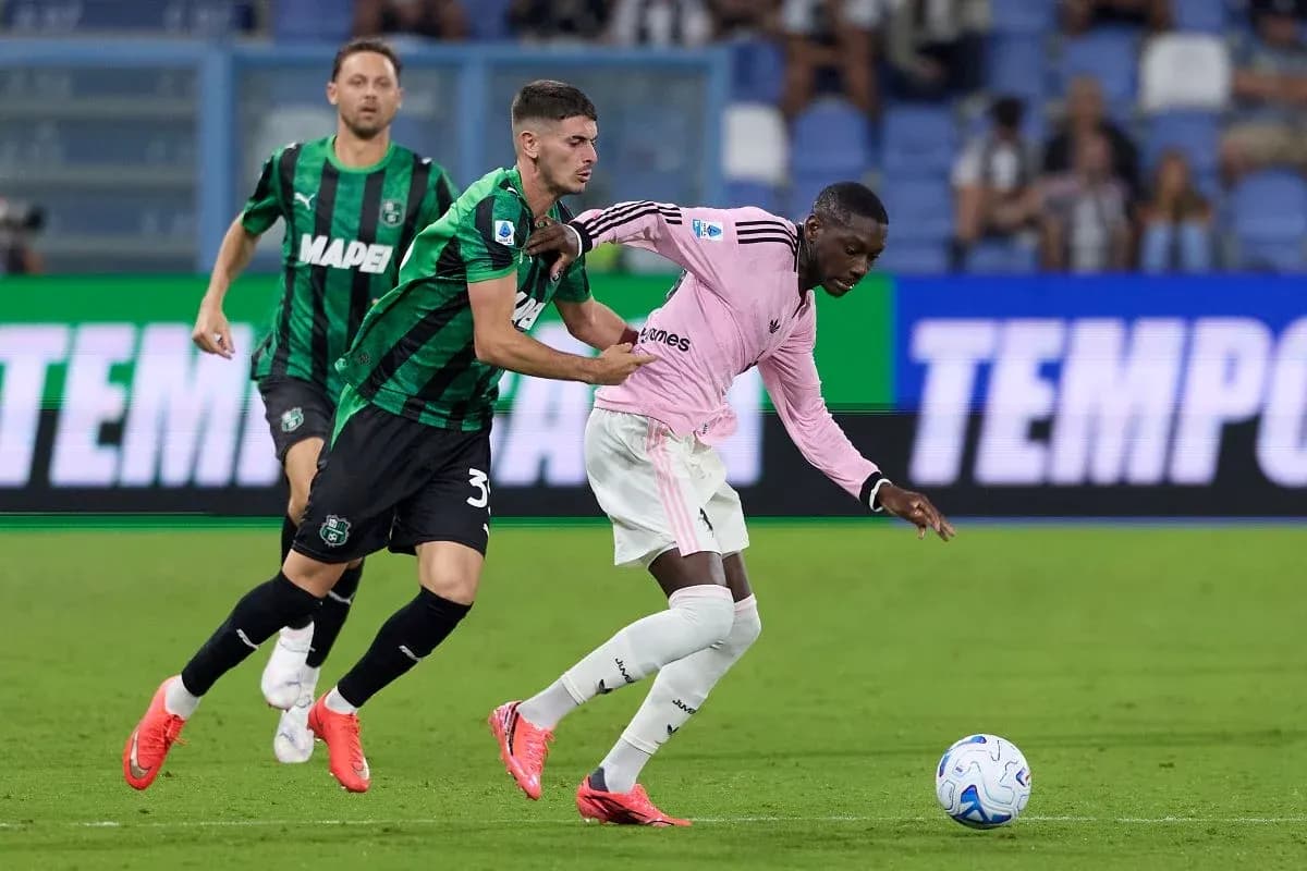 Sassuolo player tackling Juventus player during match