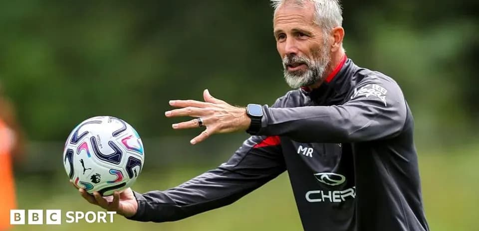 Coach demonstrating techniques while holding a football