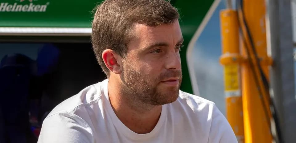 Man in white shirt sitting near racing equipment