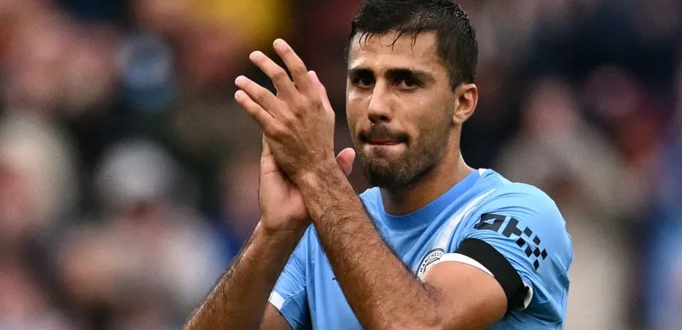 Player applauding fans after match wearing blue jersey