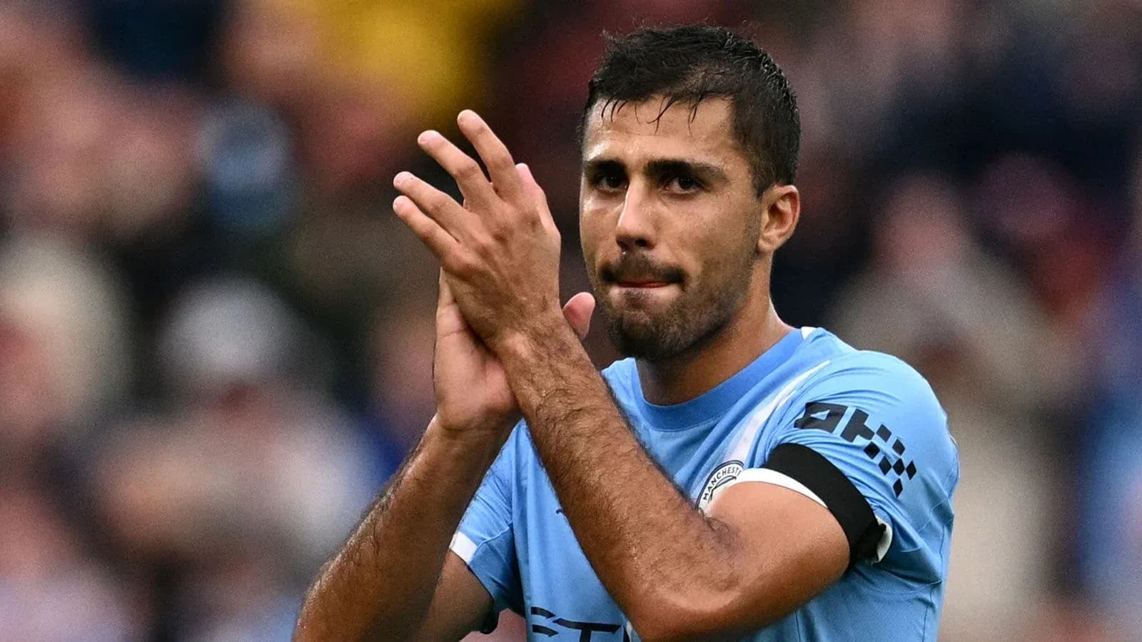 Player applauding fans after match wearing blue jersey