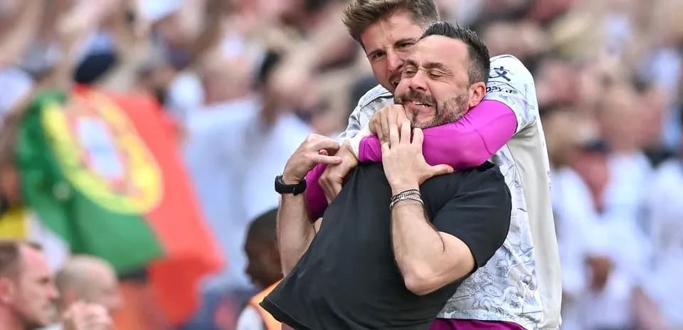 Two coaches celebrating in a crowded stadium