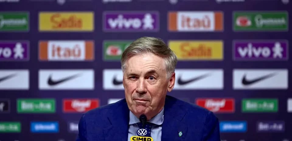 Coach speaking at press conference with sponsor backdrop
