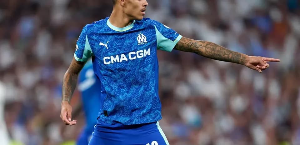 Player in blue Marseille kit directing teammates on field