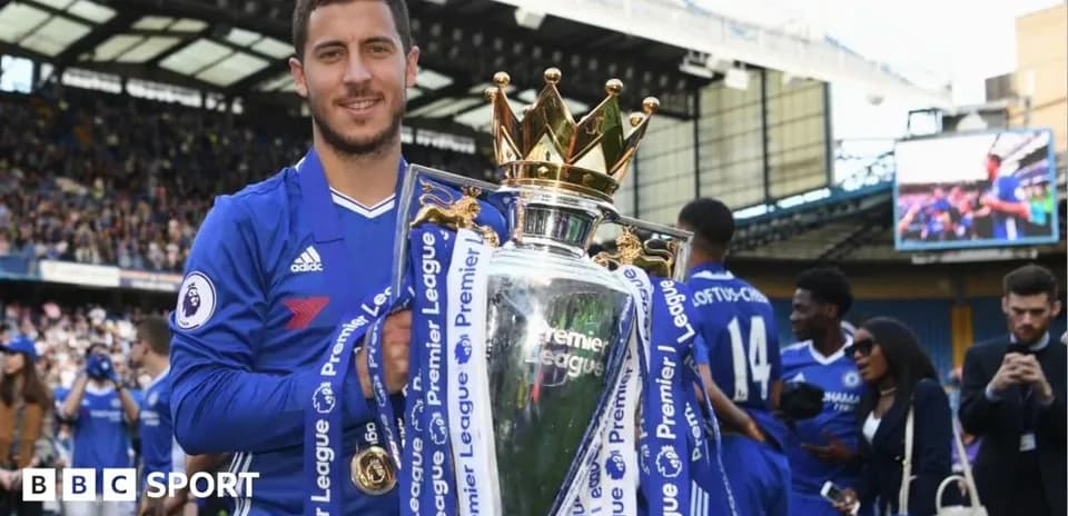 Player holding Premier League trophy at stadium