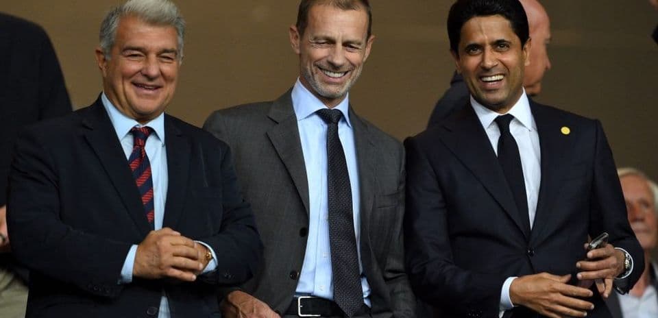 Three officials smiling during a sporting event