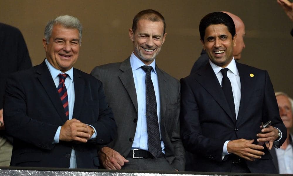 Three officials smiling during a sporting event