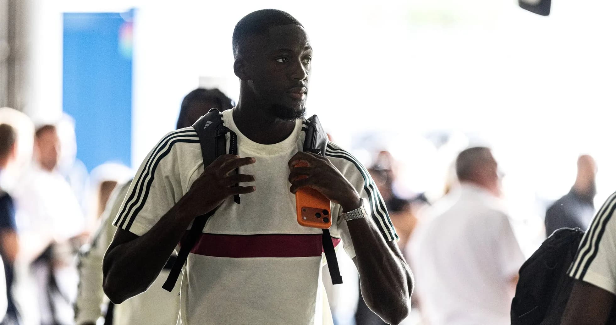 Player arriving with backpack and phone in hand