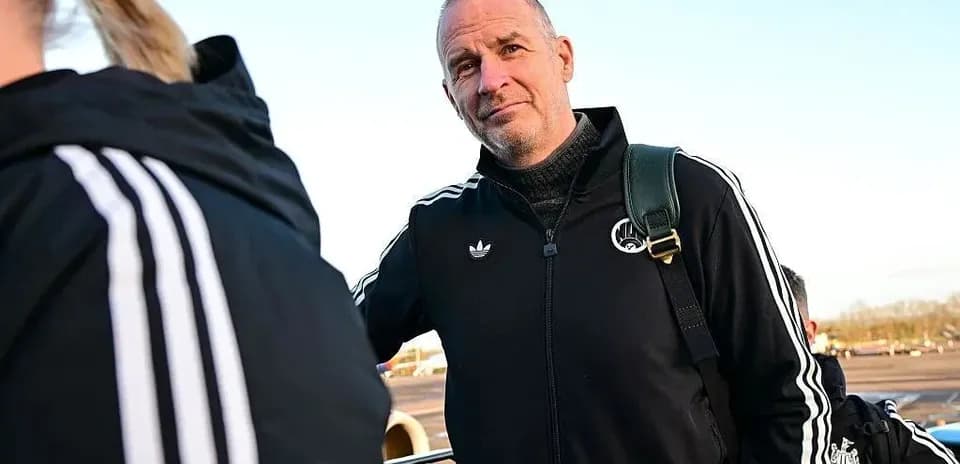 Coach standing at airport with team members