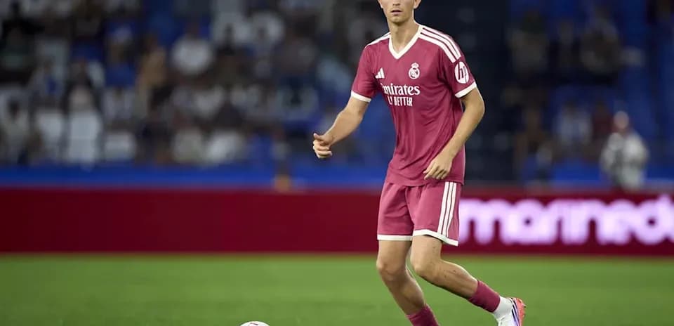 Player in pink kit controlling the ball on field