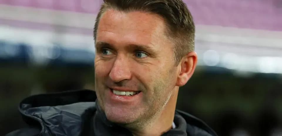 Coach smiling during match warm-up on sidelines