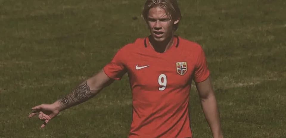 Player in red jersey gesturing during soccer match