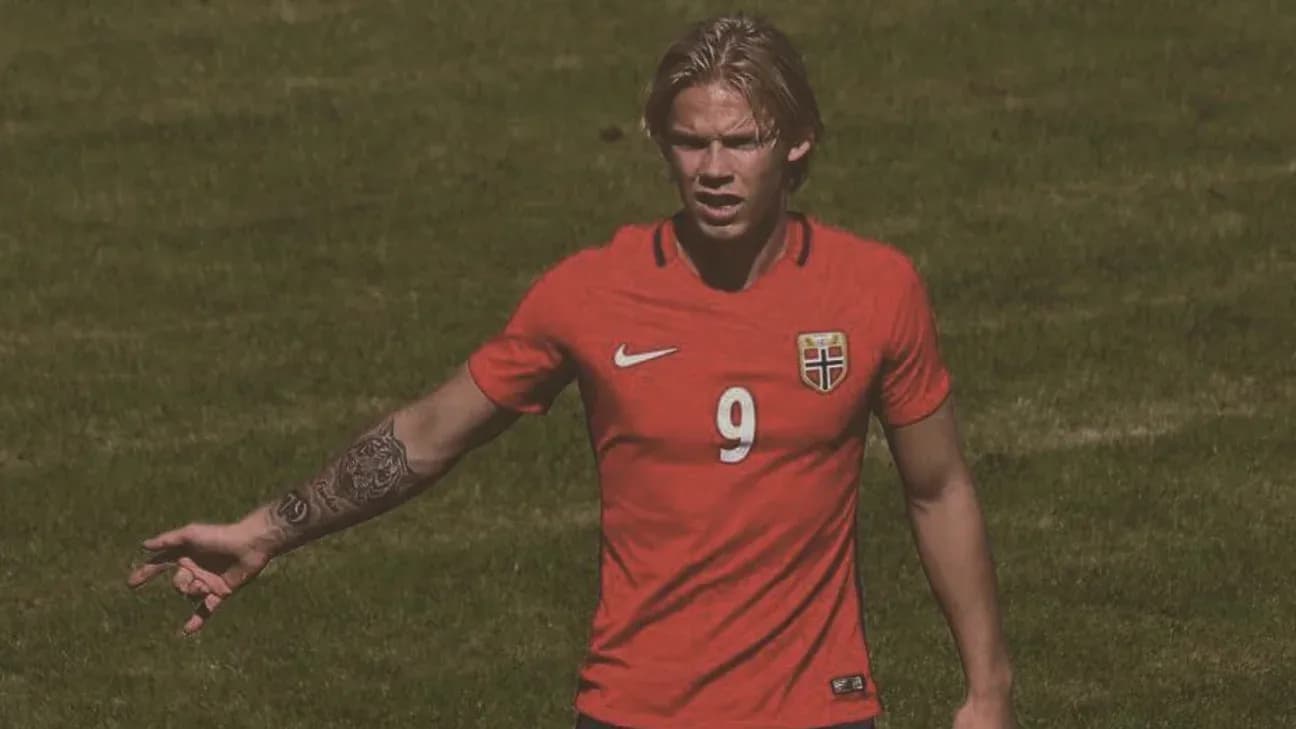 Player in red jersey gesturing during soccer match