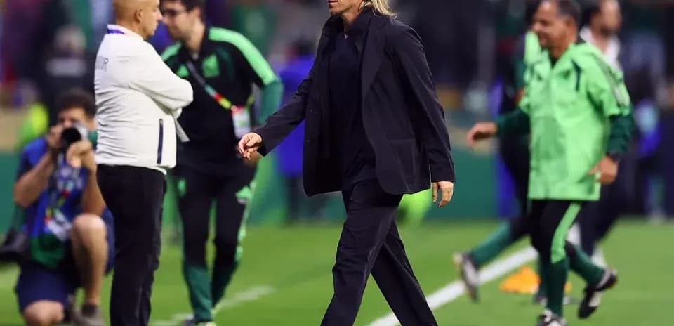 Coach walking on field during match with staff