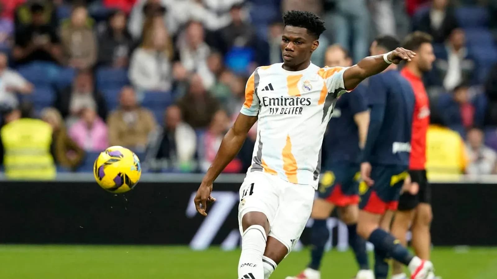 Player in Real Madrid kit kicking a soccer ball
