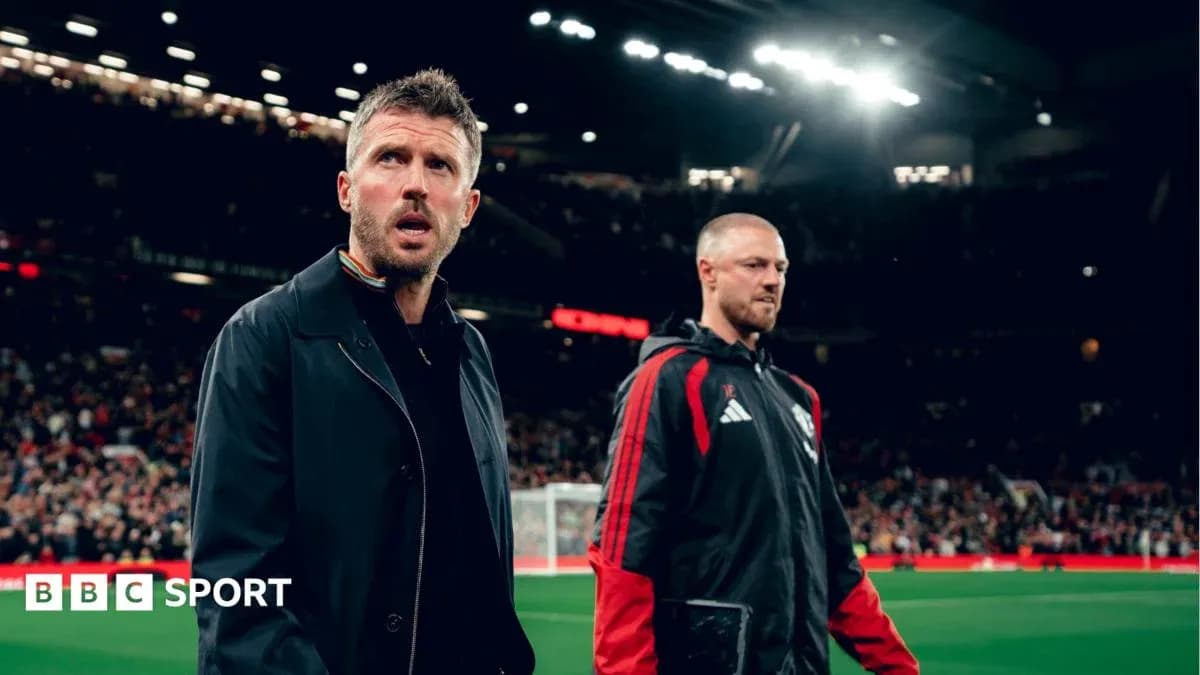 Coaches walking on the pitch at Old Trafford