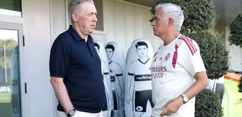 Two coaches conversing near training ground equipment