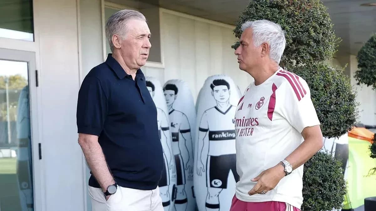 Two coaches conversing near training ground equipment