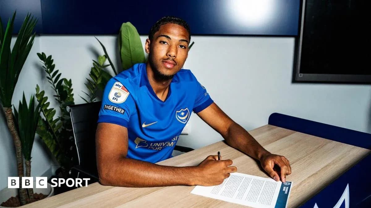 Player signing contract at desk in club jersey